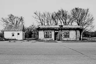 A dilapidated restaurant and car service station.