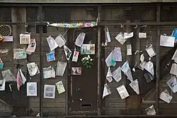 Notes and photos on a wire fence.