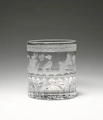 clear cup with engravings that include a dog