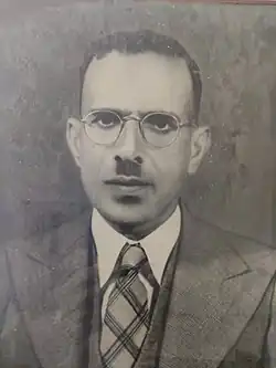 A black-and-white photograph of Mathai in his 40s. He is wearing round glasses and has a toothbrush moustache, as well as short, dark hair.