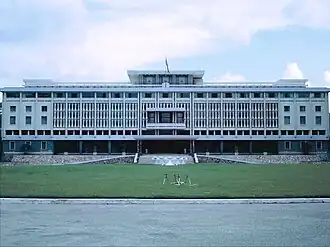 an expansive white government building with rows of columns resembling bamboo trees acting as a brise-soleil