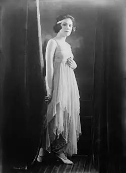 A young white woman standing in a sequined gown