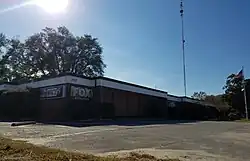 A one-story brick building with WECT and WSFX logo signage