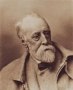 An elderly and extremely tired looking man with a thinning hair and a long white beard