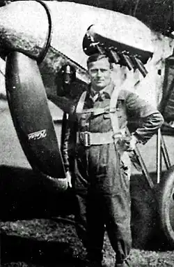 Black and white photograph of a pilot in front of a propeller fighter plane