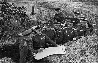 Командование Центрального фронта накануне Курской битвы. Район станции Поныри. Слева направо: командующий фронтом генерал армии К. К. Рокоссовский, командир 1-й гвардейской отдельной инженерной бригады особого назначения (1 гв. оинжбр СПЕЦНАЗ) гвардии полковник Михаил Фадеевич Иоффе (лица не видно на кадре, с карандашом), член Военного совета фронта генерал-майор К. Ф. Телегин, член Военного Совета фронта по тылу генерал-майор М. М. Стахурский, командующий артиллерией фронта генерал-лейтенант артиллерии В. И. Казаков, командующий 16-й воздушной армией генерал-лейтенант авиации С. И. Руденко, начальник штаба фронта генерал-лейтенант М. С. Малинин, начальник инженерных войск фронта генерал-майор А. И. Прошляков, заместитель командующего фронтом генерал-лейтенант И. Г. Захаркин