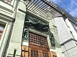 Вид на скульптуру слева и снизу с пилястрами и козырьком.