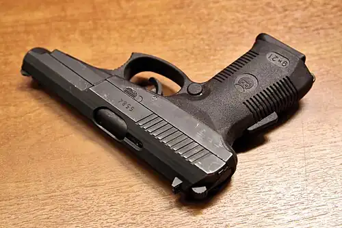 СР-1 рукояточный механизм предохранителя запирает шептало и отключается с полным охватом рукоятки ладонью, его кнопка-клавиша расположена на тыльной стороне рукоятки. (второй предохранитель запирает спусковой крючок и выключается при нажатии указательным пальцем на кнопку, расположенную на спусковом крючке)