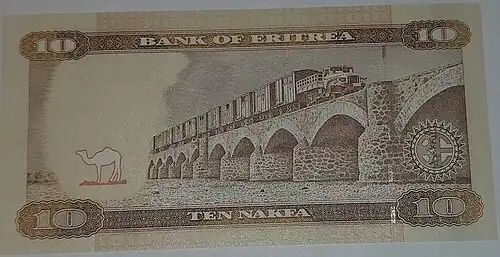 В рамке находится изображение моста с большими арками. На мосту есть железнодорожный состав. Немного в стороне от моста виден верблюд.