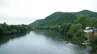 Вид на Уссури вверх по течению с моста на трассе «Осиновка — Рудная Пристань», за сопкой — село Цветковка.