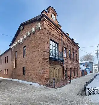 На фотографии видна пристройка, лицевой фасад и бывший глухой фасад