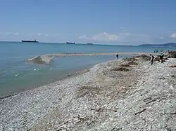 Коса из гальки при впадении реки в море (размывается при шторме)