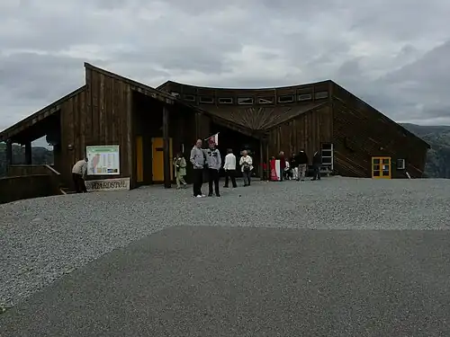 Вход в кафе, вид с парковки. На заднем плане — отвесные стены фьорда.