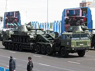 Танковый тягач ТА-4410 китайского производства, транспортирует САУ 2С3