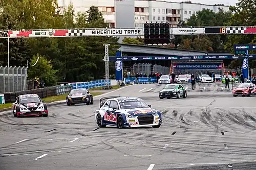 Автогонки на трассе «Бикерниеки», на фоне домов по ул. С. Эйзенштейна.