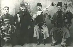 Ансамбль Мешади Джамиля Амирова. Слева направо: парная нагара Шошан, ханенде Мешади Мамед Фарзалиев, тарист Мешади Джамиль Амиров, кеманчист Левон Гараханов. Гянджа, 1919 год