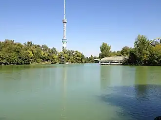 Озеро Ташкентского аквапарка, вид с юга. На левом берегу — Японский сад, на правом берегу — Ташкентский Диснейленд. На заднем плане — Ташкентская телебашня