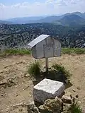 Самодельный домик и столбик, обозначающий границу Франции и Испании, установленные на вершине