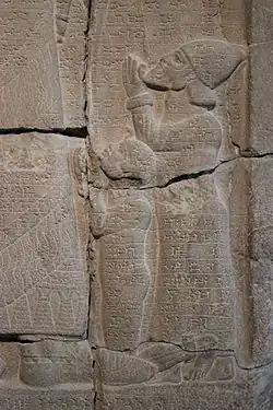 Победная стела Асархаддона (фрагмент).  Возможно, стоящая фигура — Абдмилькат.  Пергамский музей. Берлин