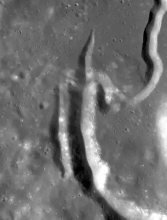 Бела — самое большое углубление в центре. Параллельная впадина слева — Тайзо; с заострённым концом сверху — Карлос, извилистая борозда справа вверху — борозда Хэдли. Снимок зонда Lunar Reconnaissance Orbiter, 2009