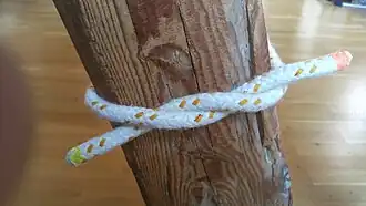 полуузел на середине шнурка с предметом между серединой шнурка и полуузлом — связывающий узел