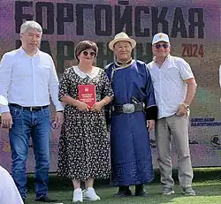 Глава Бурятии Алексей Цыденов, глава Джидинского района Валерий Шагжитаров и депутат Народного Хурала Сергей Пашинский награждают жителей района