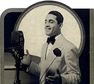 A white man of the 1930s looks at an early-20th-century microphone