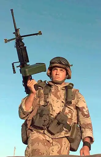 Рядовой первого класса армии США из 10-й горной дивизии из Рочестера, штат Нью-Йорк, Стивен Баттл, держащий пулемет M249 в правой руке, внимательно следит за дорогой, ведущей к перекрестку, на котором он находится во время рейда на сомалийскую деревню Афгойе на закате. Эта миссия является прямой поддержкой операции «Возрождение надежды». В специальном подсумке на левой подтяжке ремня находится Угловой мини-фонарь военного образца.