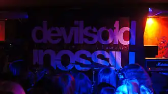 Плакат на сцене во время выступления группы в 2011 году