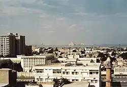 Вид на Доху в 1980-х годах, на котором изображён отель Шератон, Западная бухта (похожее на пирамиду здание на заднем плане) без каких-либо высотных зданий вокруг него