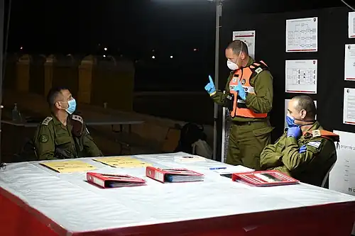 Командир дивизии Ха-Эш Ярон Финкельман (в центре) объясняет Ядаю (справа) и начальнику штаба Авиву Кохави (слева) об операции бригады по раздаче продовольствия в Бней-Браке во время вспышки коронавируса в Израиле, 2020 год