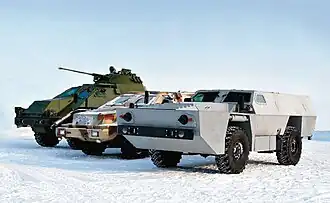 Боевые машины завода КАМАЗ. Справа налево: бронированная колёсная машина ВДВ на узлах и агрегатах КАМАЗ-43501, КАМАЗ-43269 «Выстрел», опытное бронешасси 6×6 «Воин» с башней БМП-2.