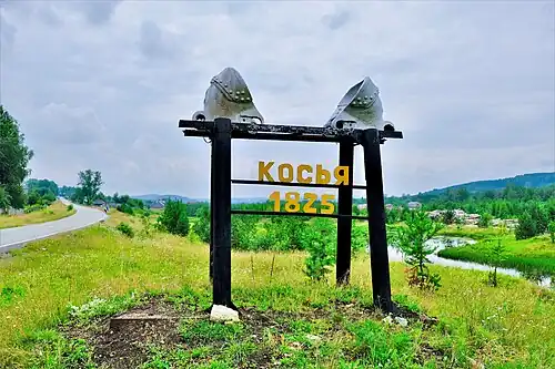 Стела в виде дражных ковшей на въезде в посёлок