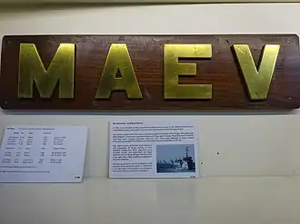 Доска с названием «Maev» в музее