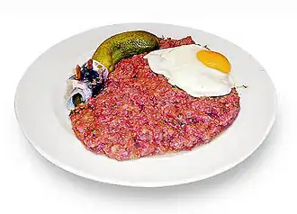 Лабскаус по-гамбургски с глазуньей, маринованным огурцом и рольмопсом