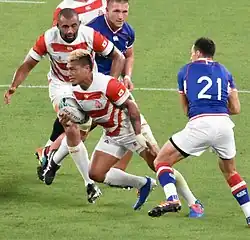 Дмитрий Перов (номер 21) в борьбе против Ломано Лемеки на чемпионате мира 2019 года