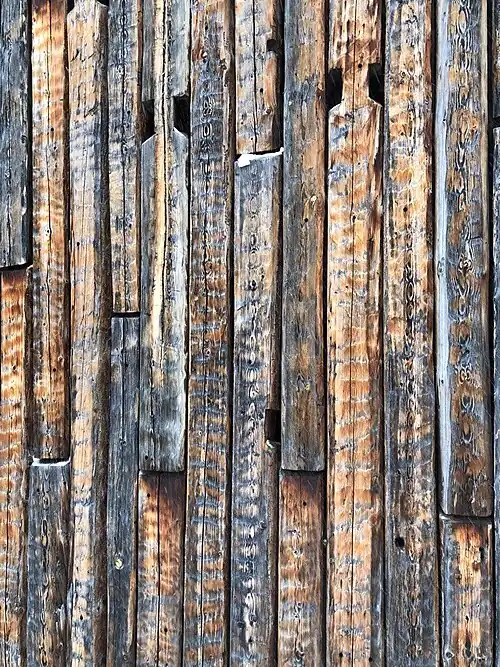 Фактурная торцовая стена здания из старого бруса