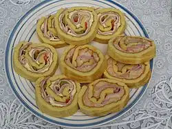 Нарезанный пикантный аргентинский пиононо с ветчиной, сыром, сальсой и овощами