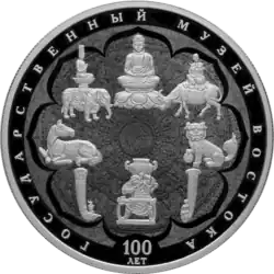 Экспонаты музея, с узором непальской мандалы в качестве фона. Серебряная монета номиналом 25 рублей.