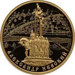 Золотая монета номиналом 100 рублей 2021 года. 800-летие со дня рождения князя Александра Невского: памятник дружинам Александра Невского на горе Соколиха на фоне панорамы средневекового Пскова