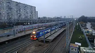 Экспресс РЭКС проходит мимо строящейся платформы, 2019 г.